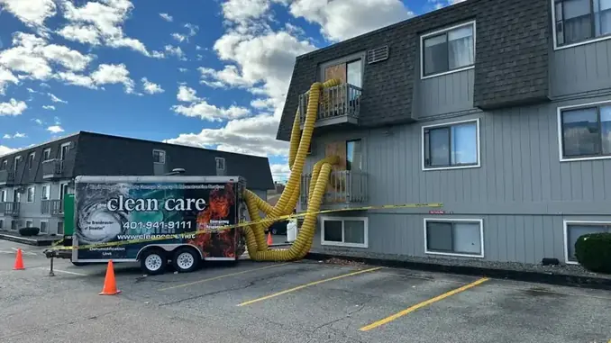 Clean Care dehumidification trailer with yellow ducting running up into a fire damaged building