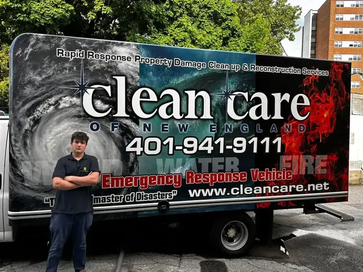 Clean Care of New England staff member standing in front of a fully liveried emergency response truck